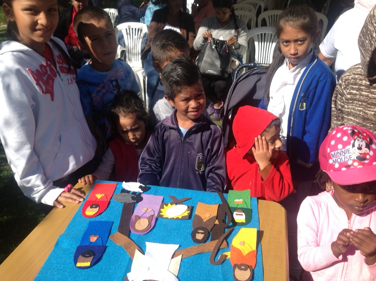Children gathered around a table of paint and paper