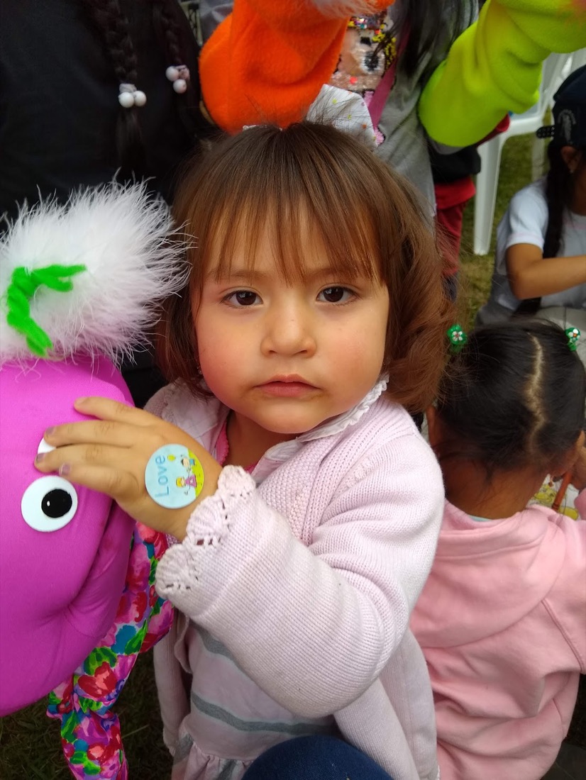A young child holding a craft puppet