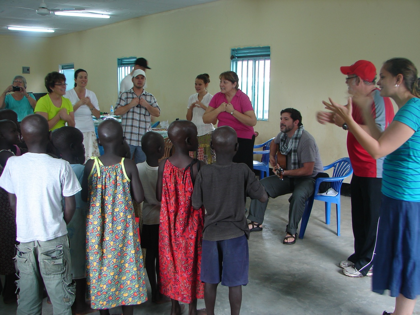 Mollie and a mission team singing with a circle of children in a classroom
